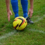 Person picking up soccer ball 